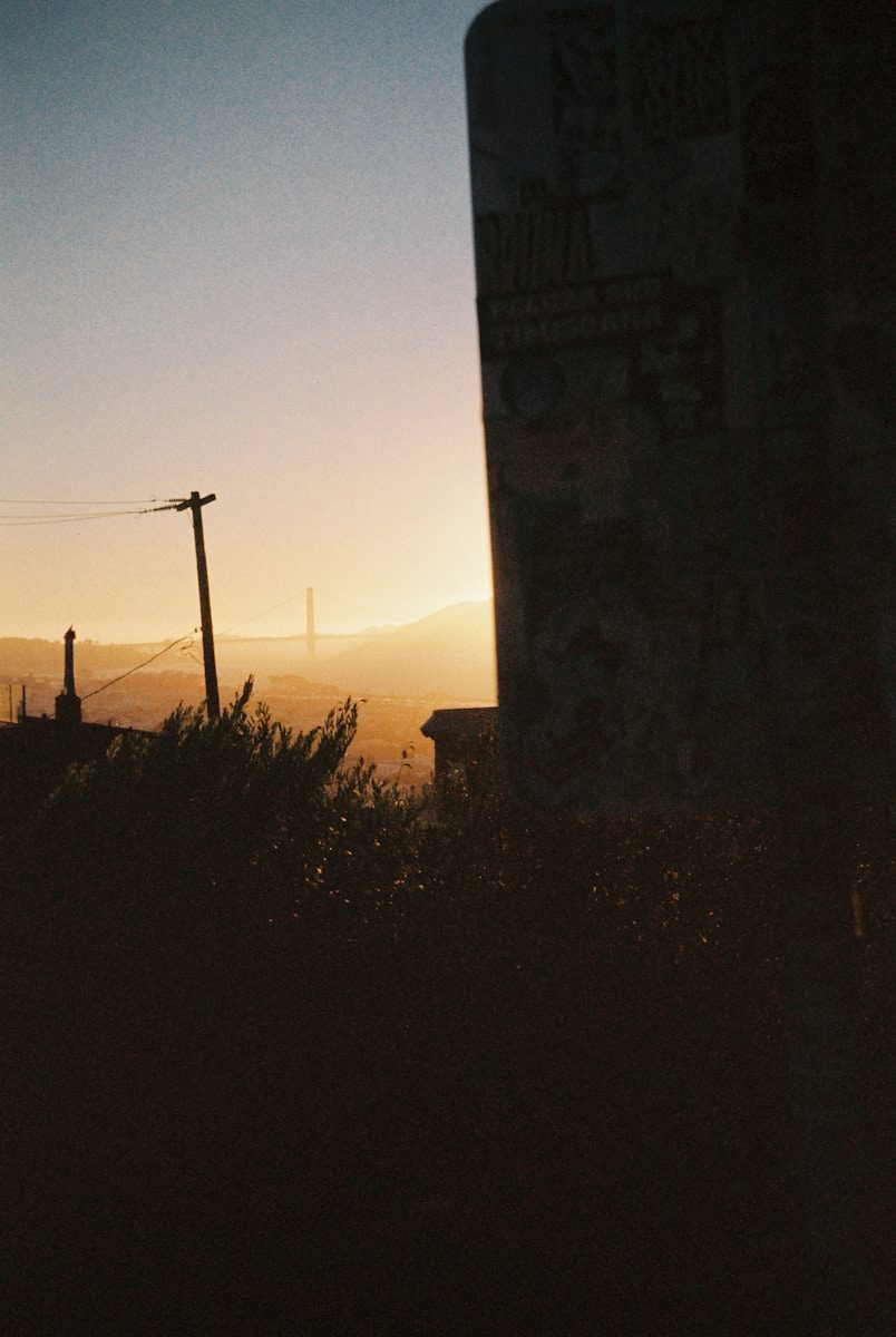 The Golden Gate Bridge in the distance under a warm glowing sky.